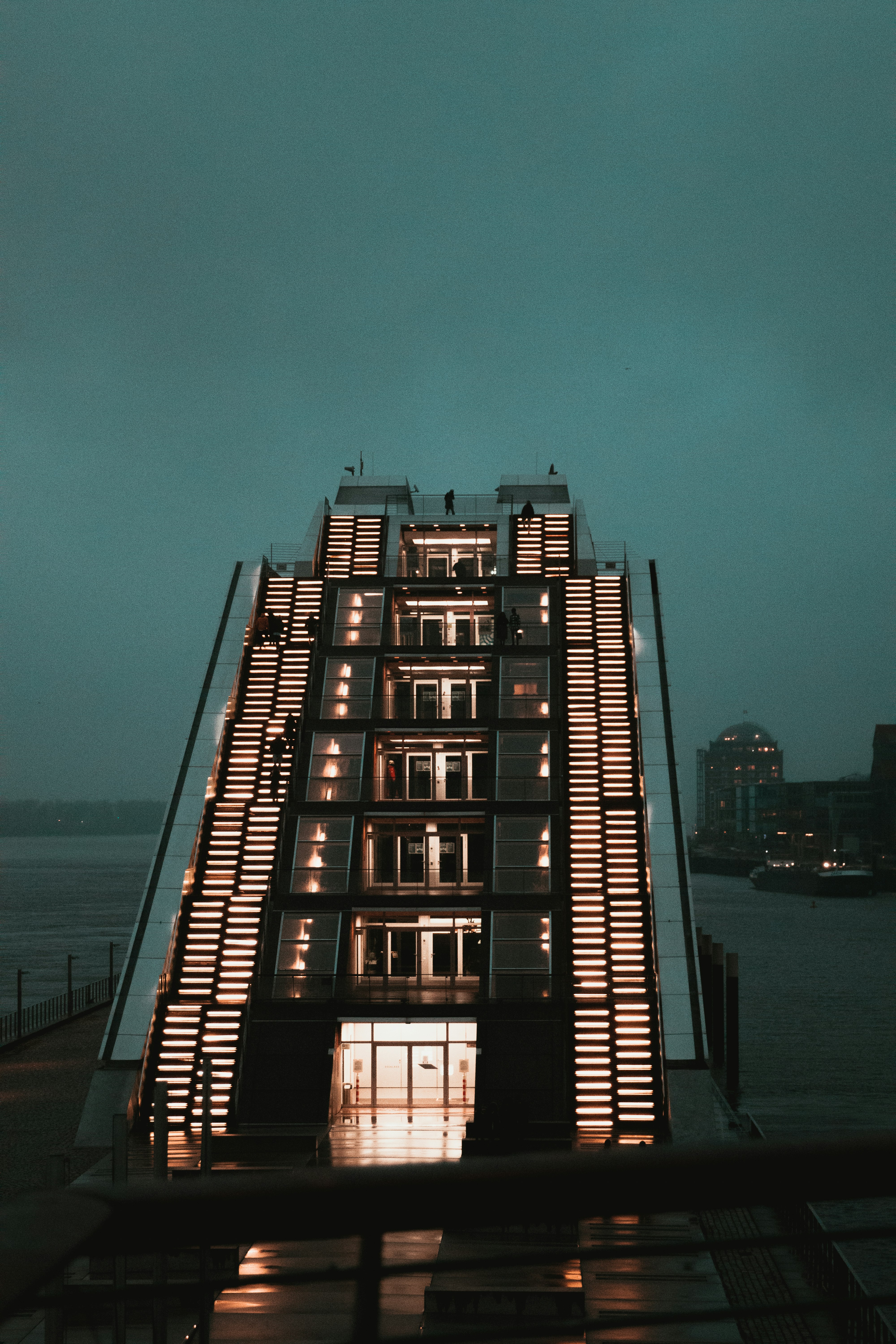 black and white building near body of water during night time